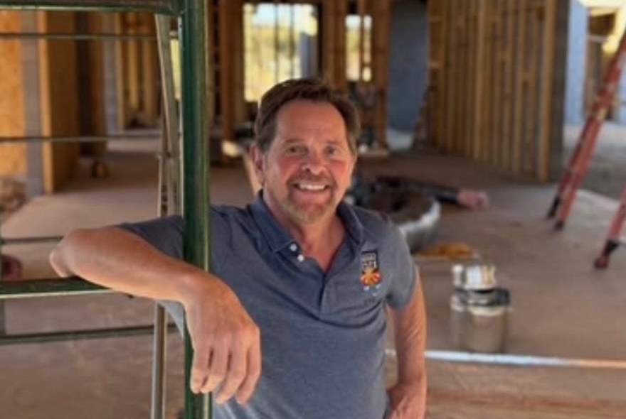 Mike Conklin, owner of Desert State Air, leaning on scaffolding at a new-construction home