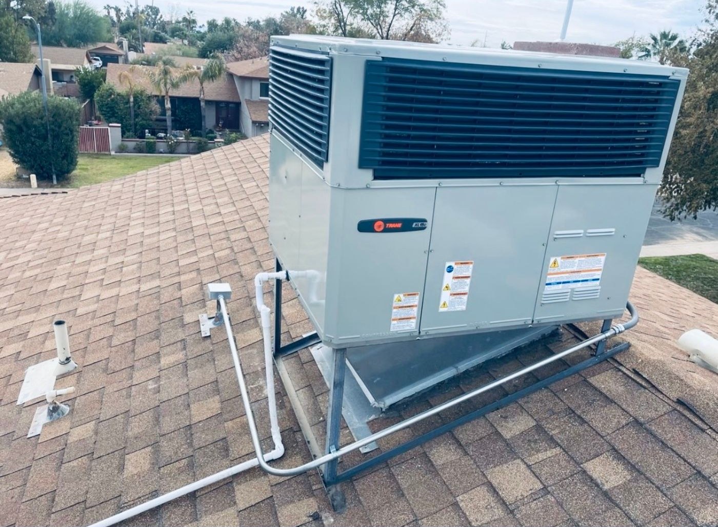 A Trane package unit on a pitched shingle roof