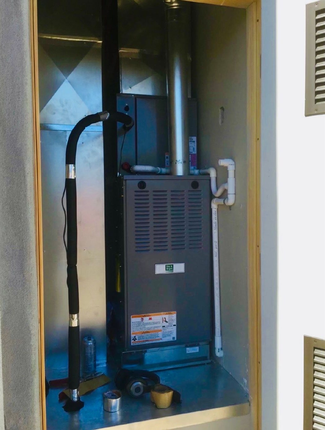 A gas furnace installed in an exterior closet with tidy piping