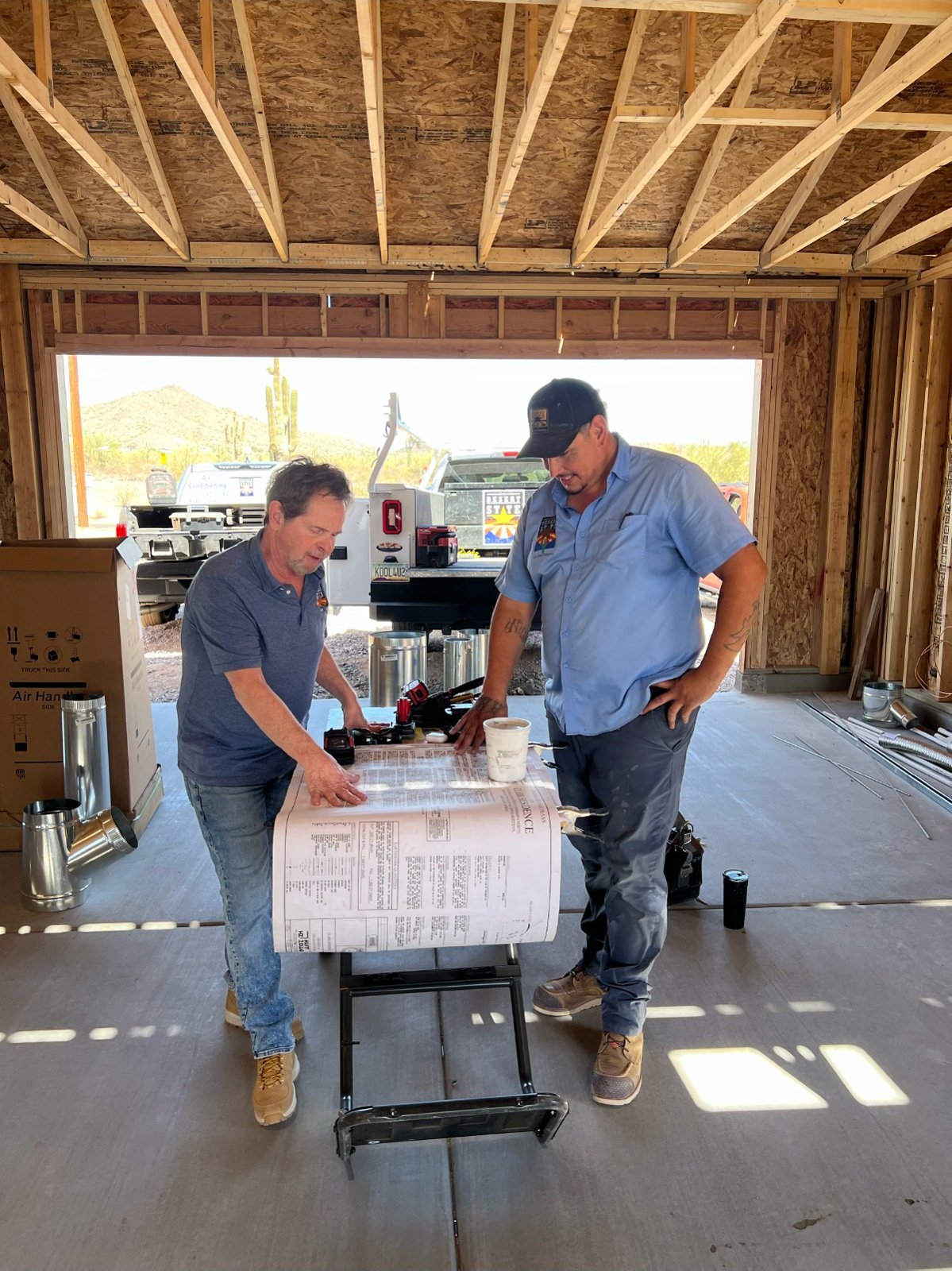 Mike Conklin reviewing plans with a crew member on a new-construction job site